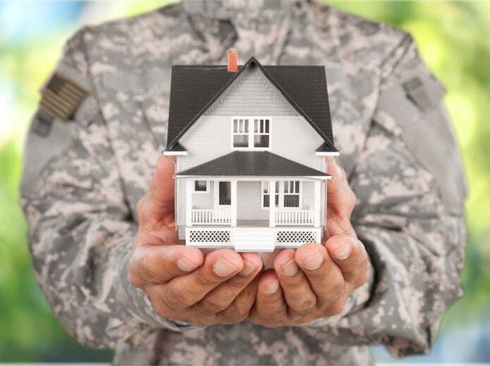 Veteran holding house in palm of hands
