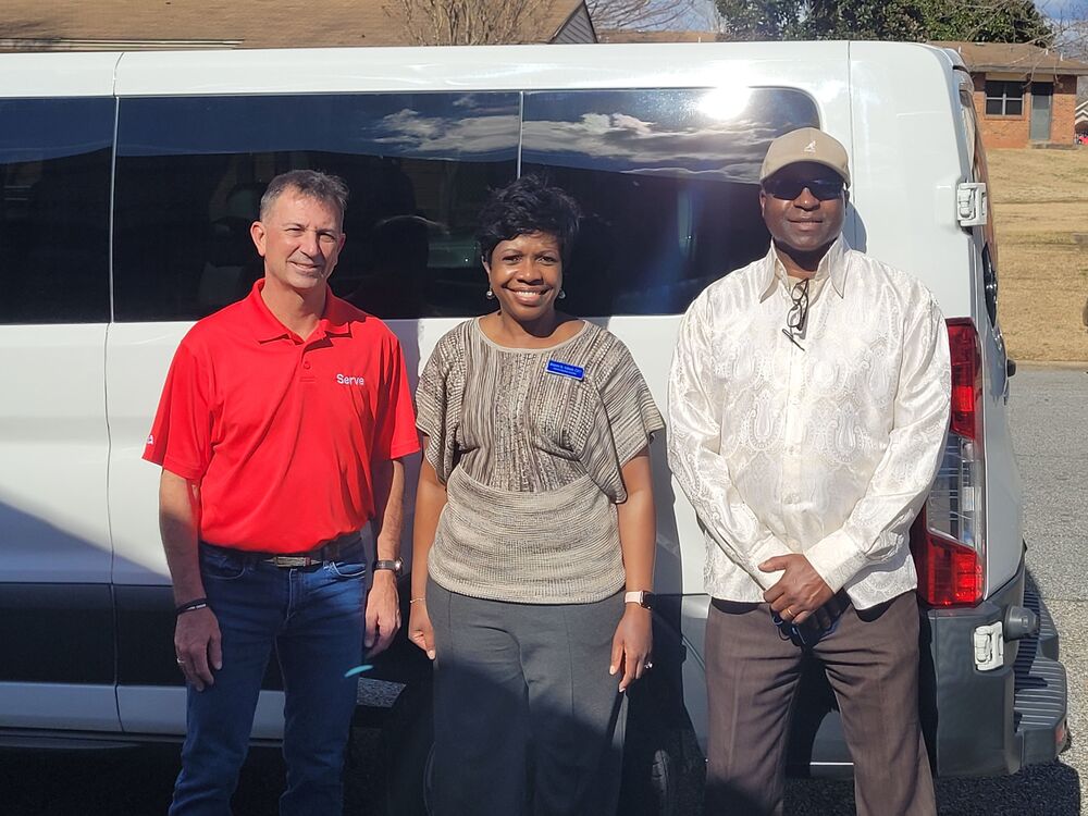 Pastor Wren, CEO Torbert, and Commissioner Tolbert posing in front of donated van.