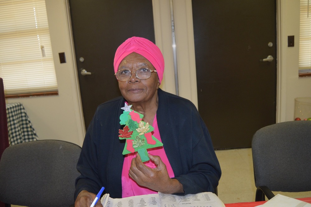 senior citizen showing off her christmas tree craft