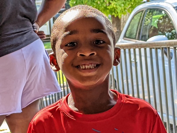 Young boy is up close and smiling at the camera