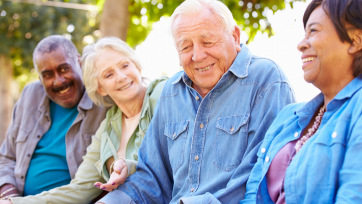 Four senior citizens sitting and enjoying each others company talking and laughing