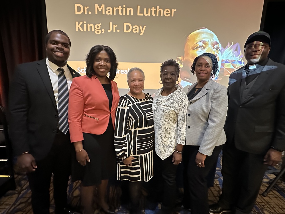 MLK Scholarship breakfast at Auburn University Hotel AHA staff and Commissioners posed in front of MLK presentation