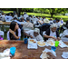 Large group of senior residents eating at picnic tables in the park