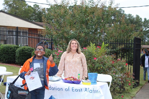 Female vendor and boy giving a thumbs up at Operation CommUNITY event.