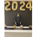 LaFayette High School graduate posing behind table under 2024 balloons in his cap and gown