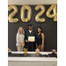 graduate in the middle of supporters holding certificate