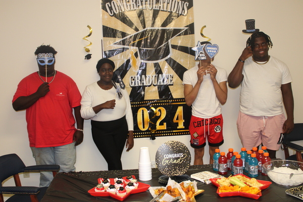 graduates posing with props