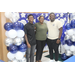 graduation attendees near balloons in front of backdrop