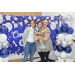 graduate younger sibiling and mother posing in front of backdrop