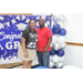 graduate and family member posing in front of backdrop