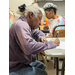 older resident writing information on paper 