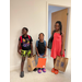 Three African American youth holding bags filled with school supplies