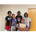 Group of African American youth various ages smiling while holding their new school supplies